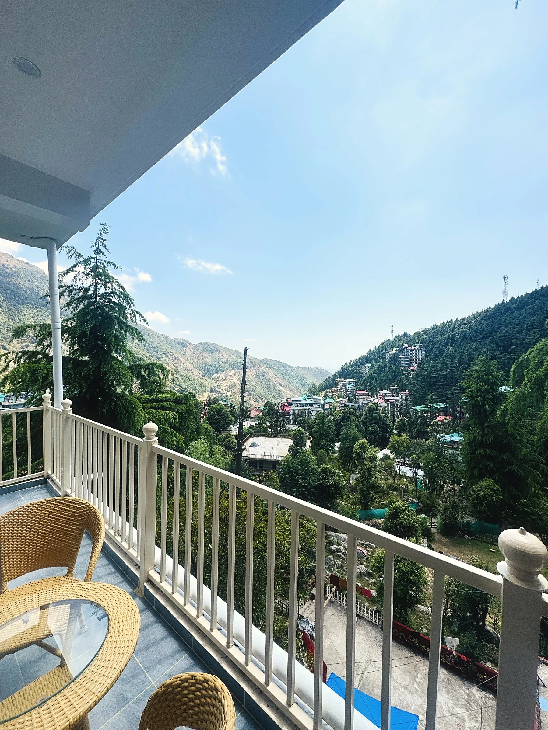 The balcony, with two cane chairs and a white railing above the valley