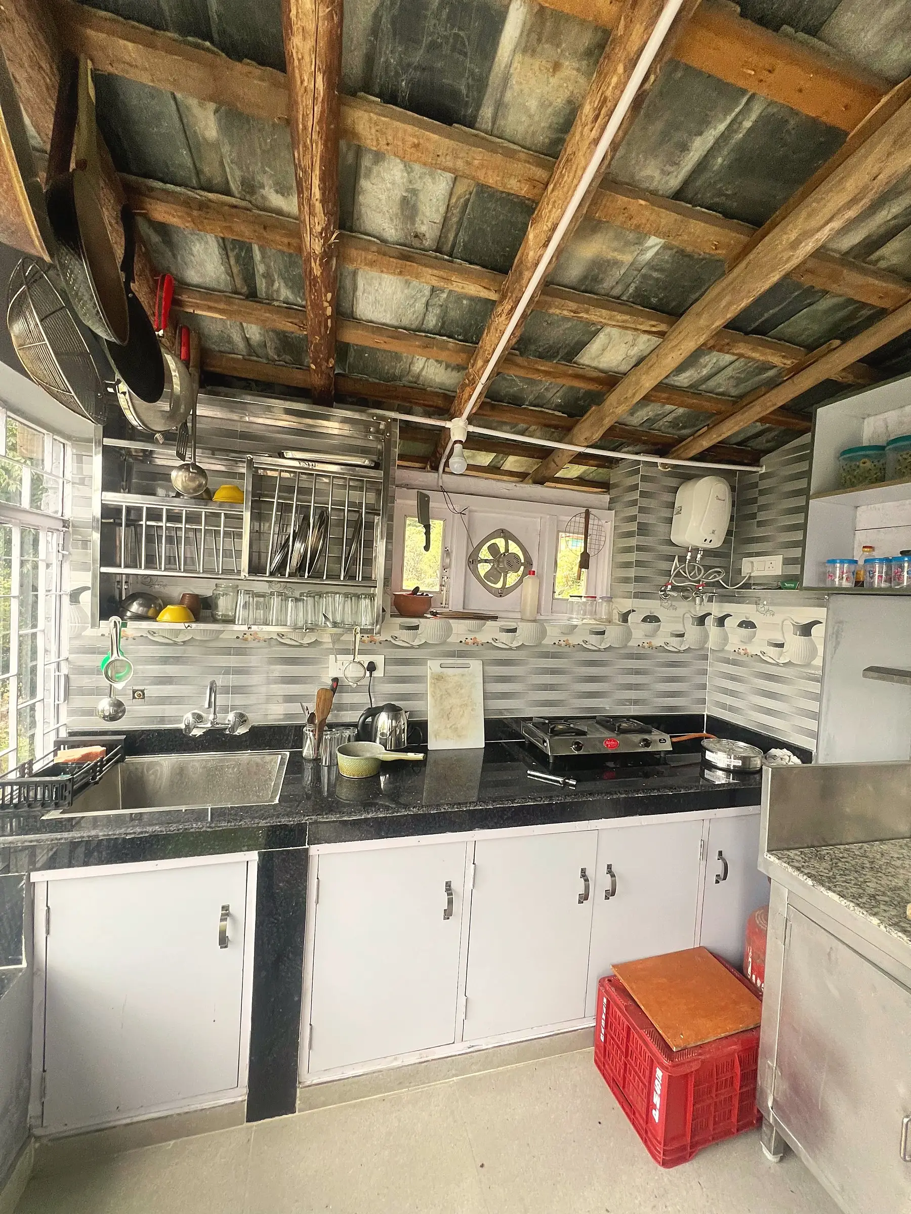 The kitchen, with a gas hob, sink and shelves of crockery