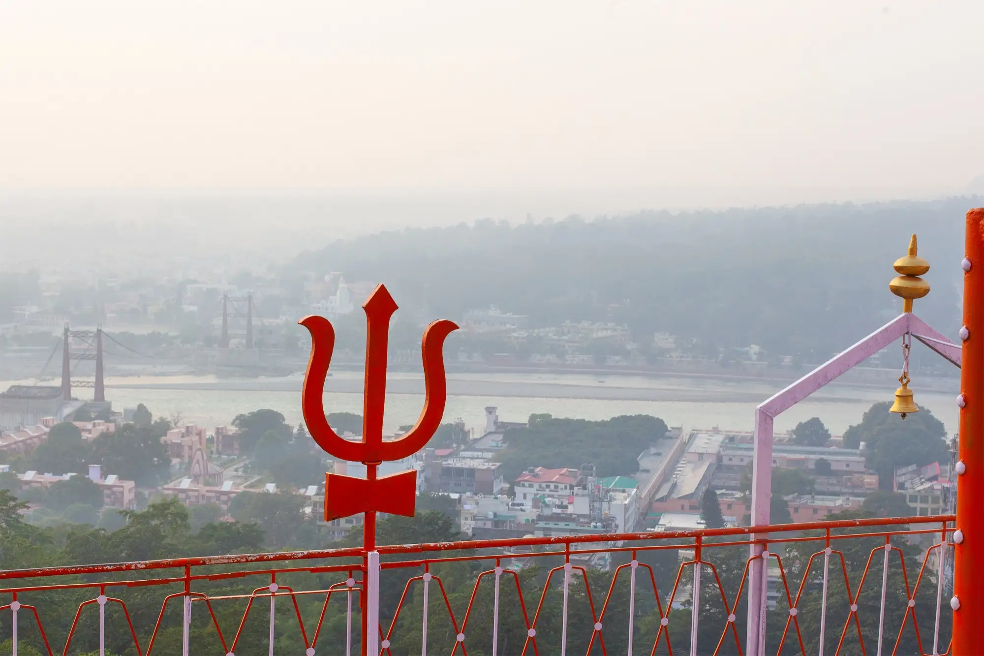 A red trident at the Bhootnath temple, with Rishikesh and the river in the haze below