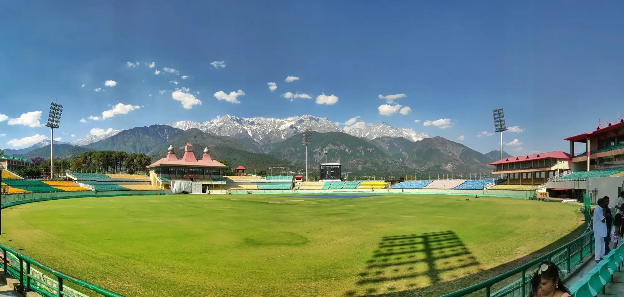 The Dharamshala cricket stadium with the snow-covered Dhauladhar behind