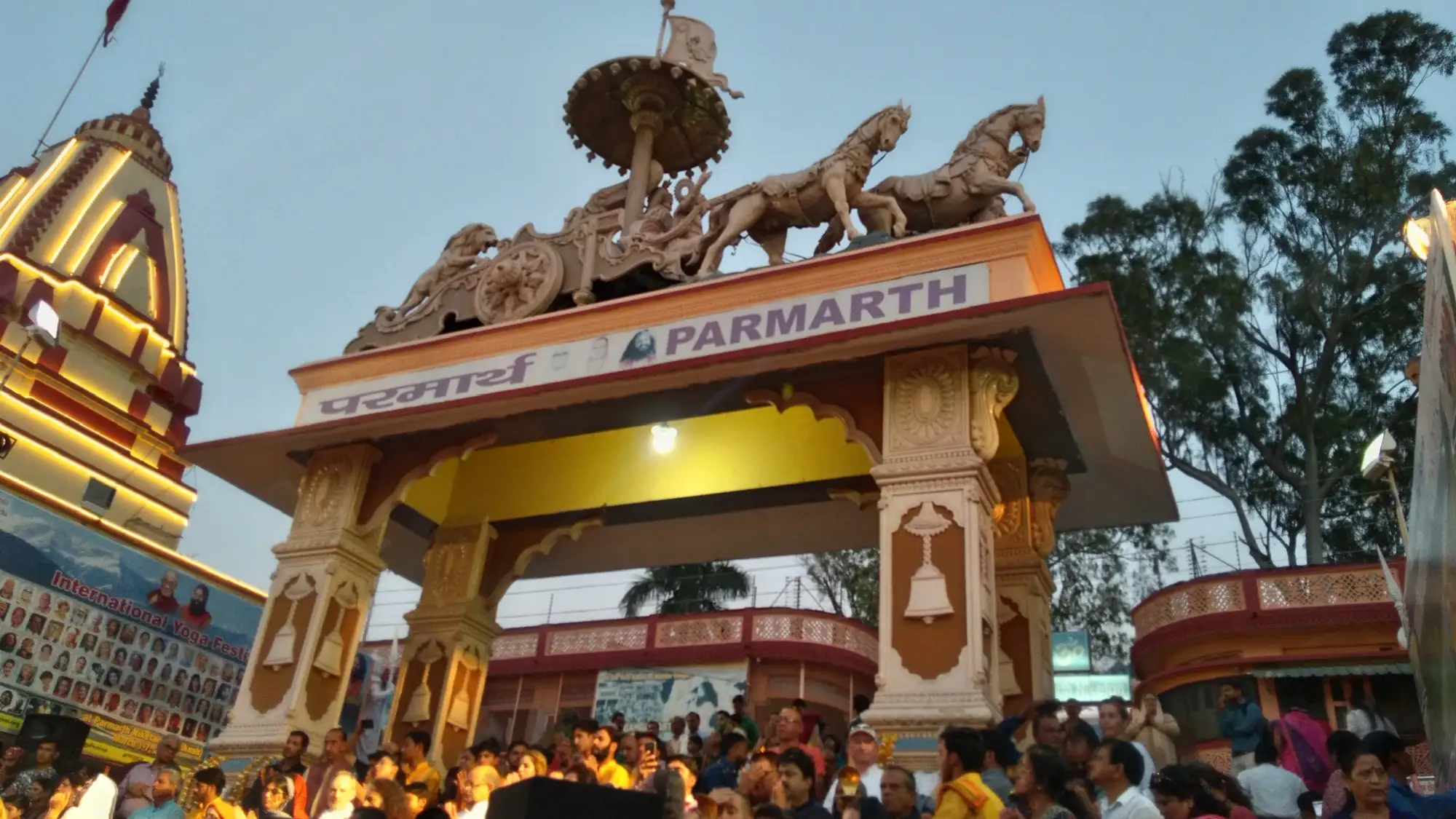 The decorated entrance gate of Parmarth Niketan ashram with a crowd in front