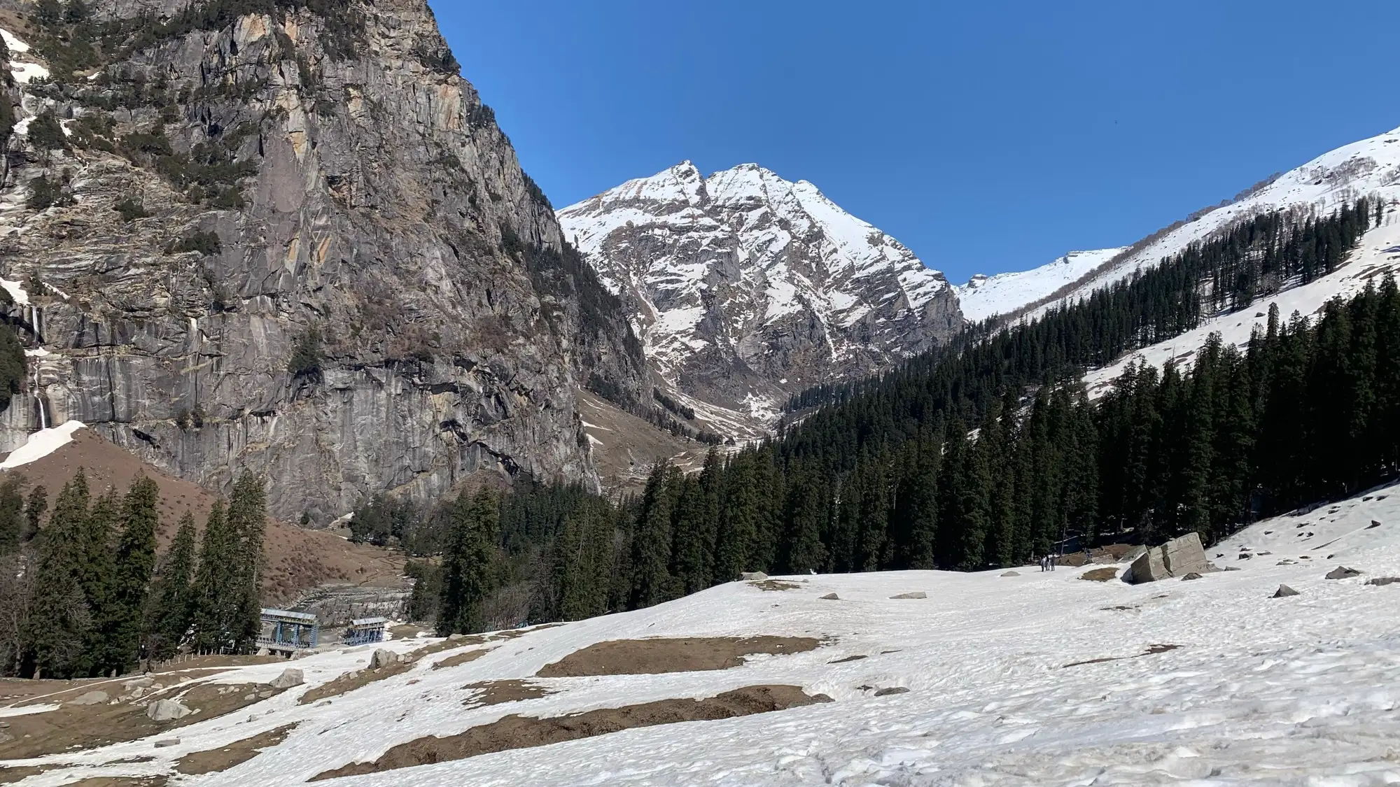 Snow on the ground at Sethan, with rock faces and peaks behind