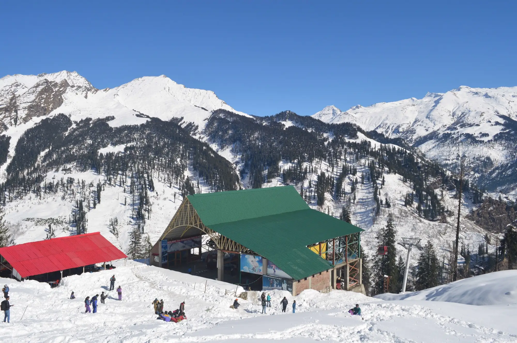 Snow-covered slopes and the green roof of the upper ropeway station at Solang near Manali
