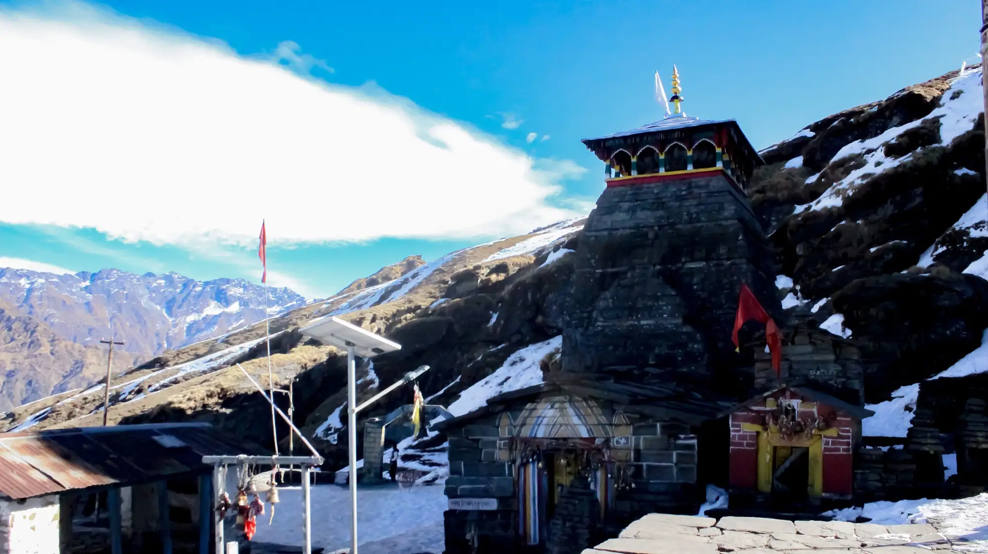 Tungnath temple on a ridge with patches of snow on the slopes behind